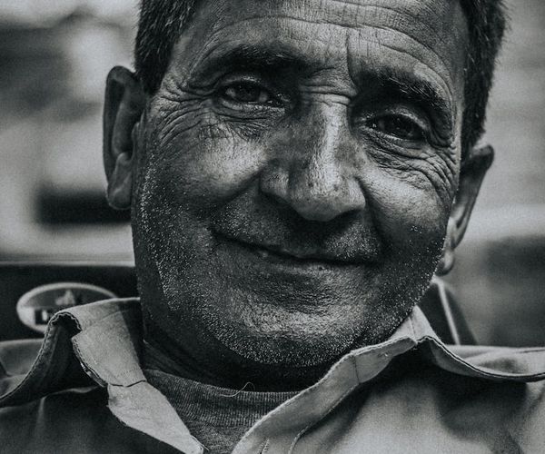 Senior man meditating peacefully outdoors with a gentle smile on his face.